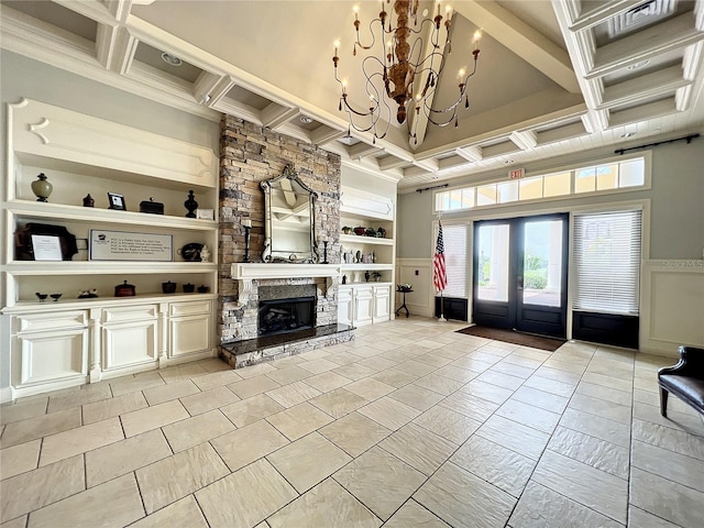 living room featuring built in shelves, coffered ceiling, an inviting chandelier, and beam ceiling