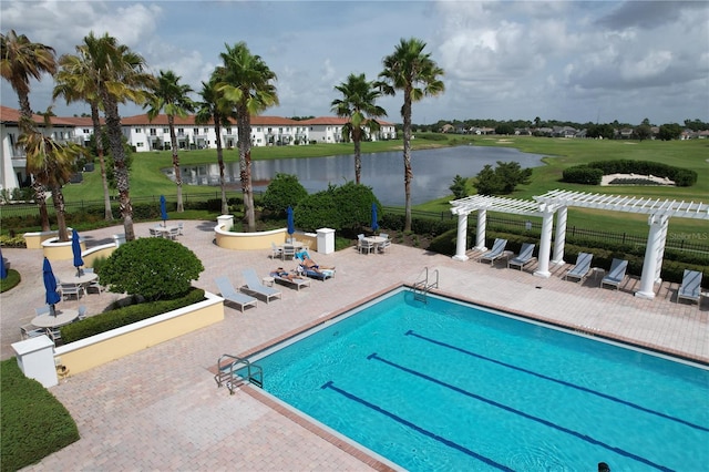 view of swimming pool with a pergola, a patio, and a water view