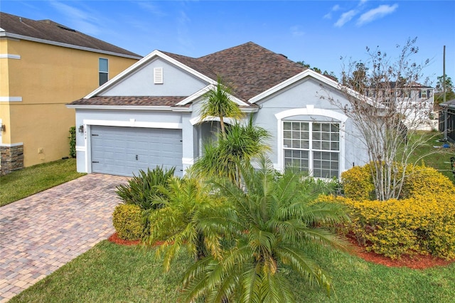 1404 Lexington Ave, Davenport, FL 33837 - view of front of house featuring a garage, roof with shingles, stucco siding, and decorative driveway