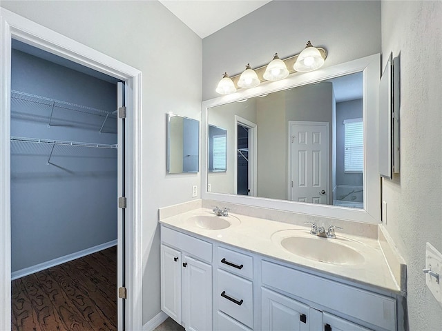 1404 Lexington Ave, Davenport, FL 33837 - full bath with double vanity, a spacious closet, wood finished floors, and a sink