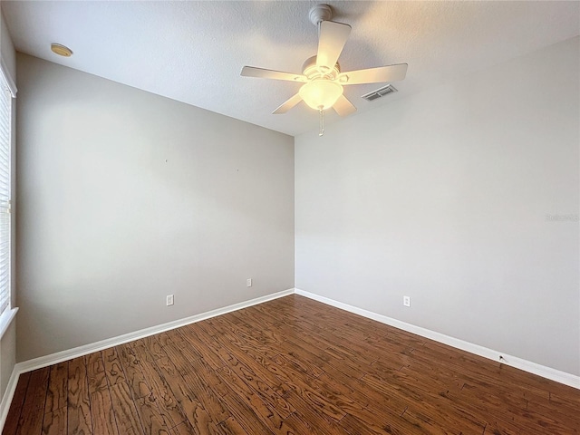 1404 Lexington Ave, Davenport, FL 33837 - unfurnished room featuring visible vents, a ceiling fan, baseboards, and dark wood-style flooring