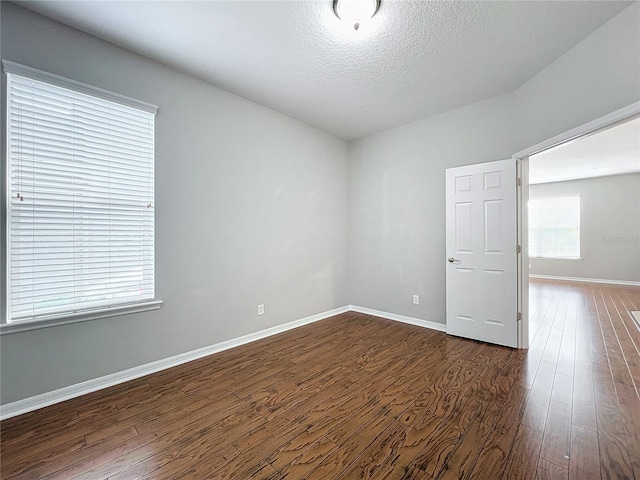 1404 Lexington Ave, Davenport, FL 33837 - unfurnished room with baseboards, dark wood-style floors, and a textured ceiling