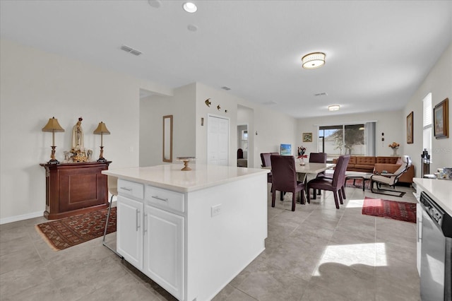 kitchen featuring white cabinetry, a center island, dishwashing machine, and light tile patterned flooring