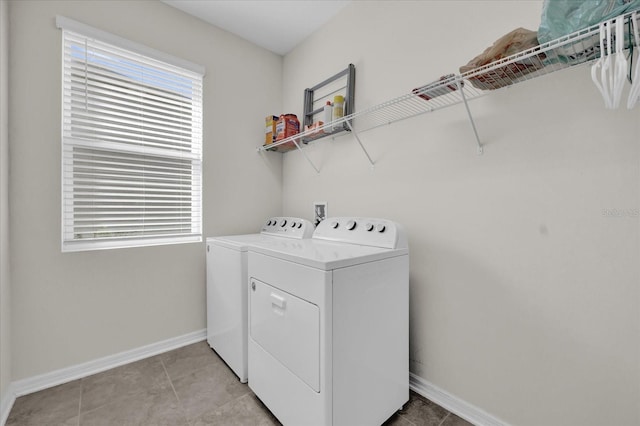 laundry area with independent washer and dryer and light tile patterned floors