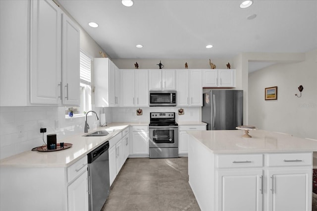 kitchen featuring stainless steel appliances, white cabinetry, a kitchen island, and decorative backsplash