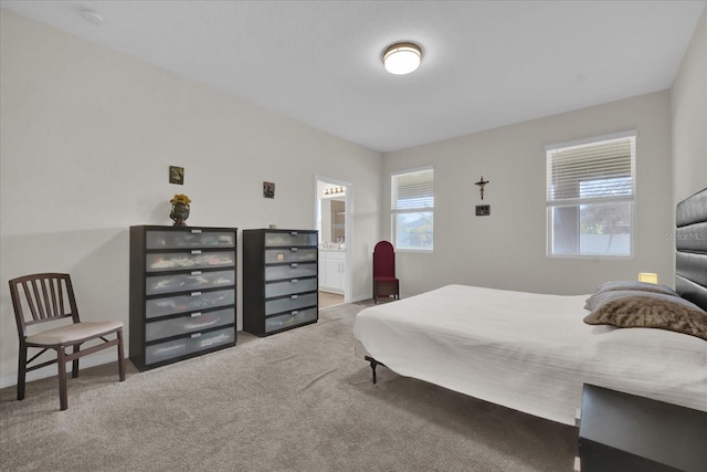 bedroom featuring connected bathroom and carpet