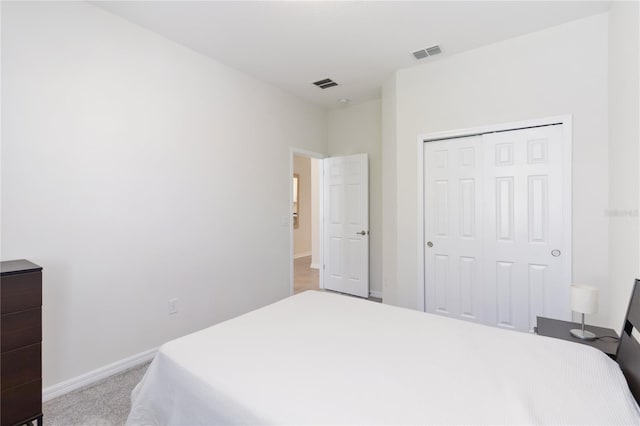 carpeted bedroom with baseboards, visible vents, and a closet