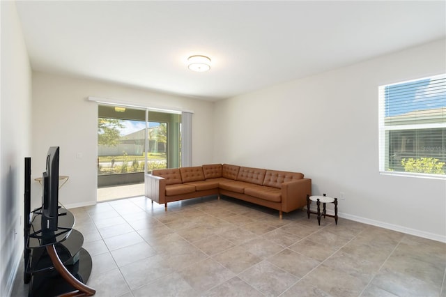 living area featuring baseboards and light tile patterned flooring