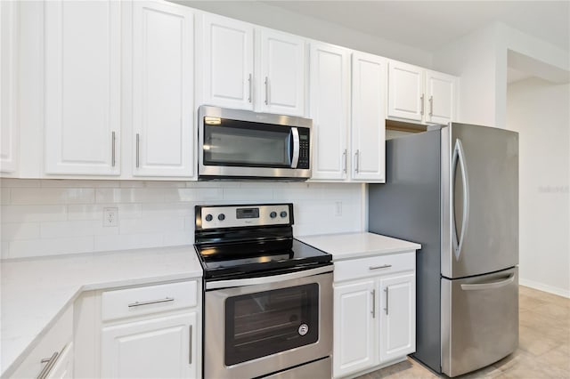 kitchen featuring white cabinets, stainless steel appliances, backsplash, and light tile patterned floors