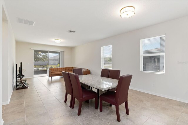 dining space with visible vents, light tile patterned floors, and plenty of natural light
