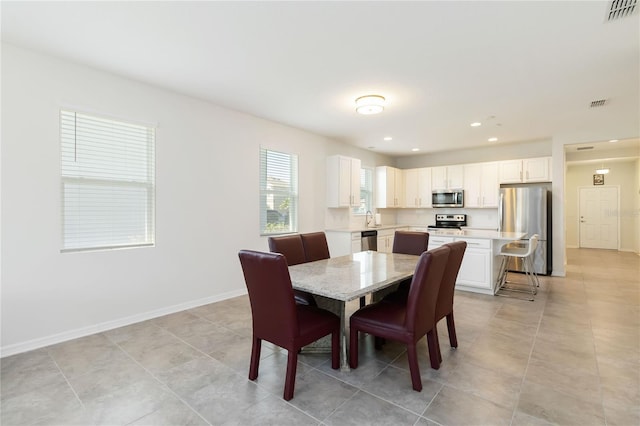 dining space featuring baseboards, visible vents, and recessed lighting