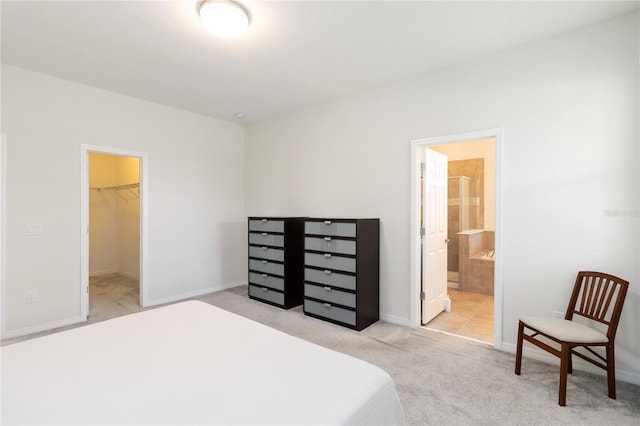 carpeted bedroom with baseboards, ensuite bath, a closet, and a spacious closet