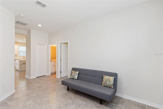 living area with baseboards, visible vents, and recessed lighting