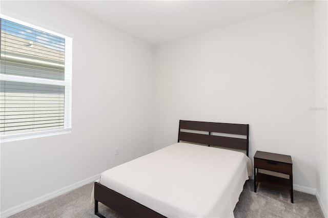 carpeted bedroom with baseboards and multiple windows