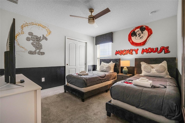 bedroom with ceiling fan, carpet, a textured ceiling, and a closet