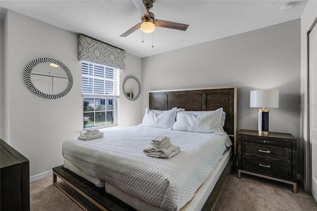 bedroom with ceiling fan, carpet floors, and a textured ceiling