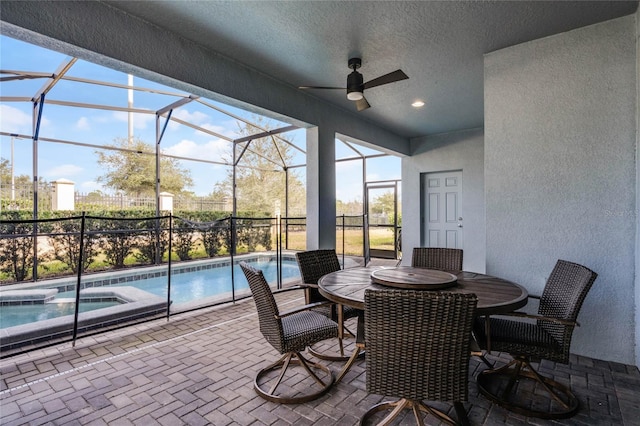 view of patio / terrace with a swimming pool with hot tub and a lanai