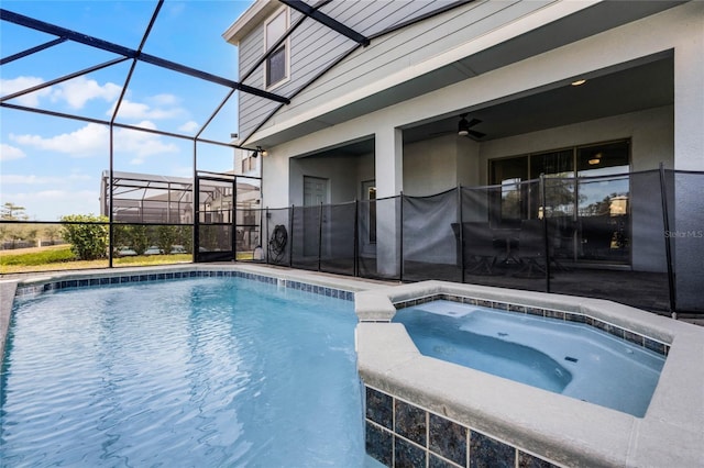 view of pool with a patio, glass enclosure, and an in ground hot tub