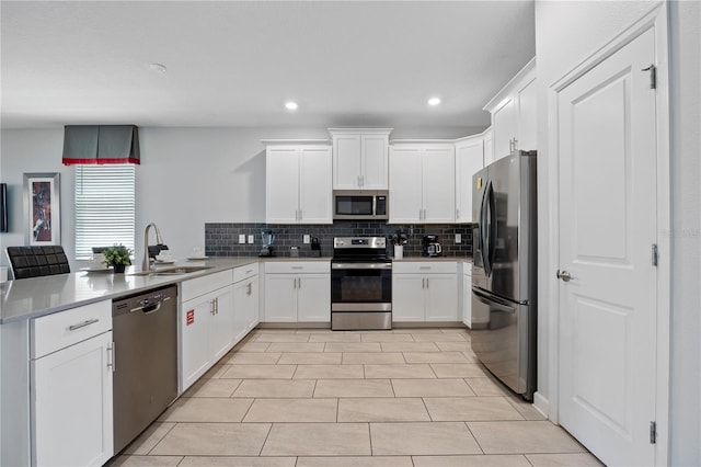 kitchen with sink, backsplash, stainless steel appliances, and white cabinets