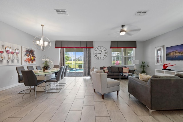 living room featuring ceiling fan with notable chandelier and plenty of natural light