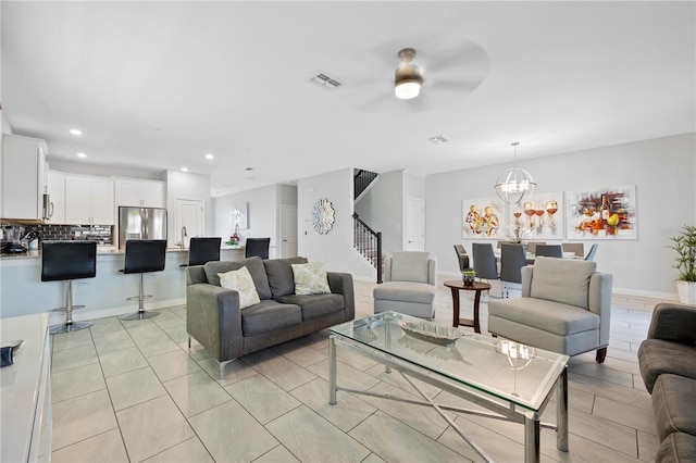 living room with ceiling fan with notable chandelier