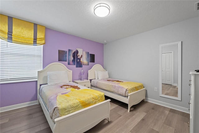 bedroom featuring hardwood / wood-style flooring and a textured ceiling