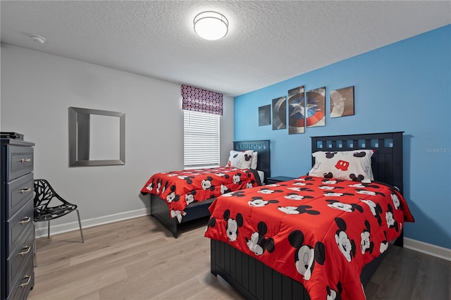 bedroom featuring a textured ceiling and light wood-type flooring