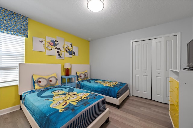 bedroom with a closet, hardwood / wood-style floors, and a textured ceiling