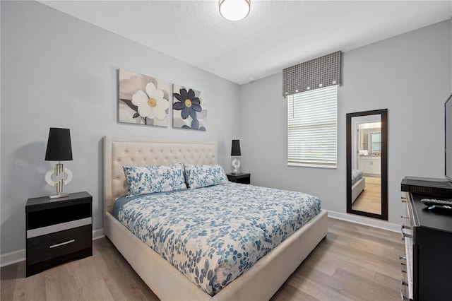 bedroom with a textured ceiling and light wood-type flooring