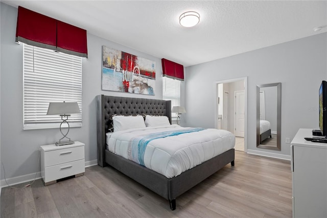 bedroom with light hardwood / wood-style flooring and a textured ceiling