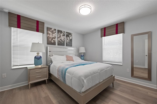 bedroom featuring hardwood / wood-style flooring and a textured ceiling