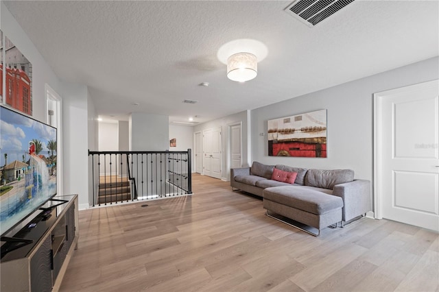 living room with light hardwood / wood-style flooring and a textured ceiling