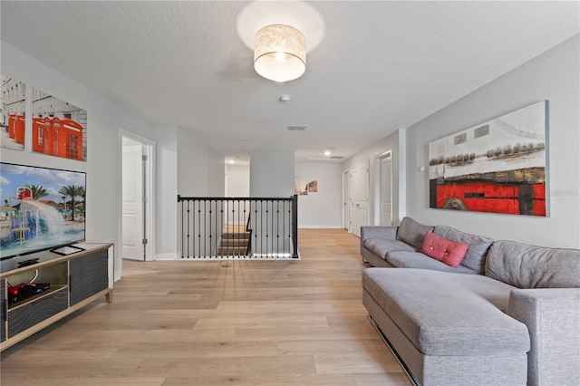 living room with light hardwood / wood-style floors and a textured ceiling