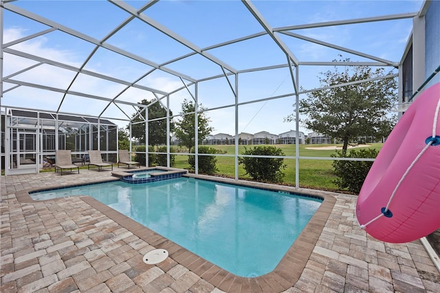 view of swimming pool with an in ground hot tub, a yard, glass enclosure, and a patio area