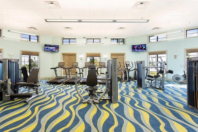 workout area with a high ceiling and carpet flooring