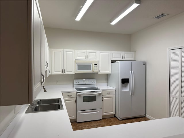 kitchen featuring white cabinetry, sink, and white appliances