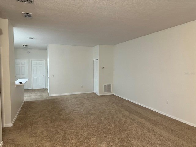 empty room featuring carpet and a textured ceiling