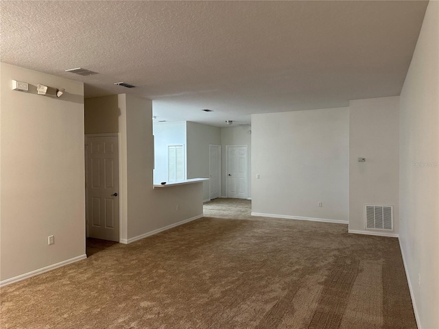 carpeted spare room featuring a textured ceiling