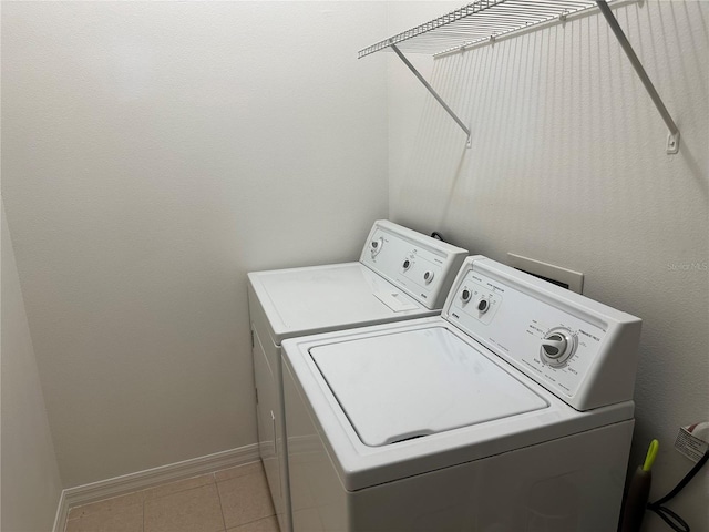 laundry area featuring light tile patterned floors and washing machine and clothes dryer