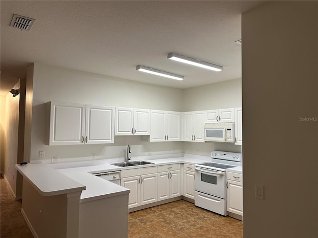 kitchen featuring white cabinetry, sink, white appliances, and kitchen peninsula