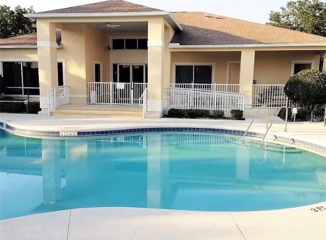 rear view of house featuring a community pool and a patio area