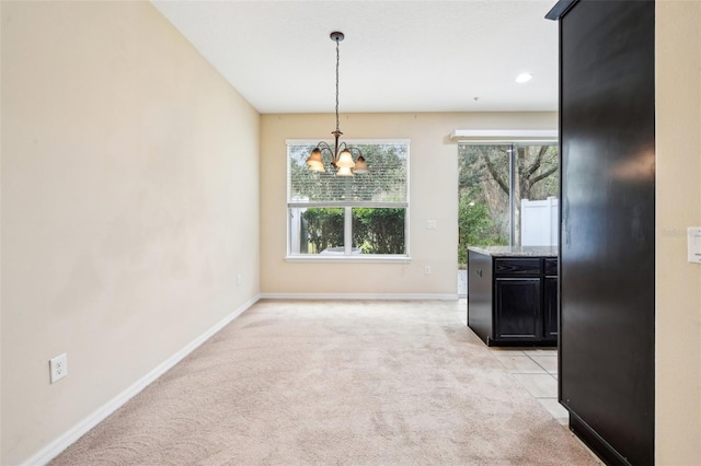 unfurnished dining area featuring light carpet and a chandelier