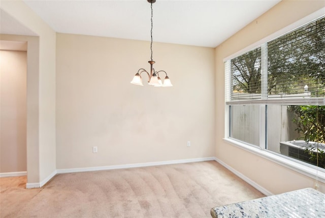 unfurnished room with light colored carpet and a chandelier