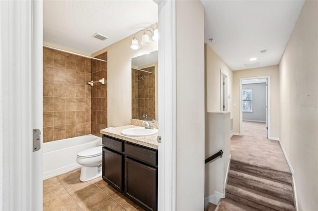 full bathroom featuring vanity, toilet, tiled shower / bath combo, and tile patterned flooring