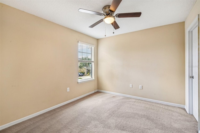 empty room with ceiling fan and light carpet