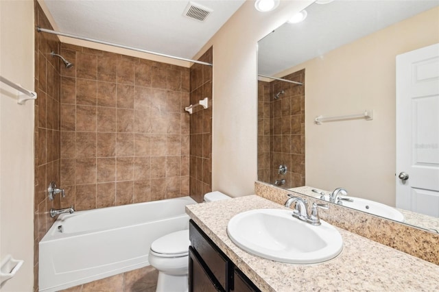 full bathroom featuring vanity, tiled shower / bath combo, tile patterned floors, and toilet