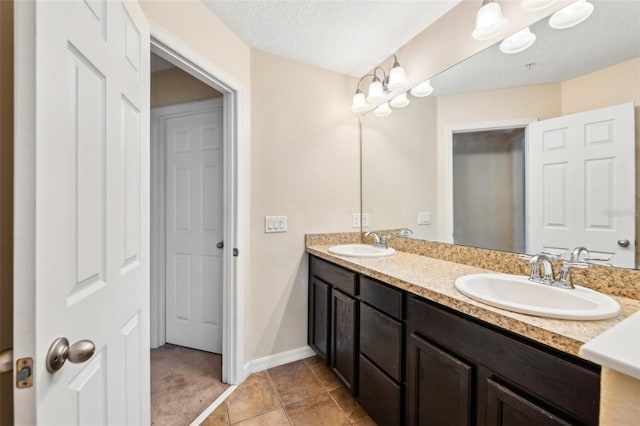 bathroom featuring vanity, tile patterned floors, and a textured ceiling