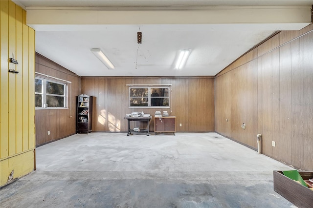 unfurnished office featuring lofted ceiling and wooden walls