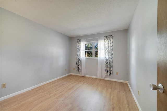 unfurnished room featuring a textured ceiling and light hardwood / wood-style floors