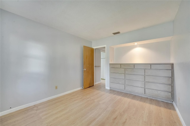 unfurnished bedroom featuring light hardwood / wood-style flooring and a textured ceiling